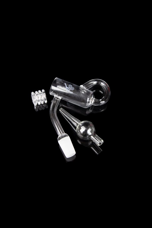 Clear glass dab rig components including a carb cap, banger, and downstem on a black background.