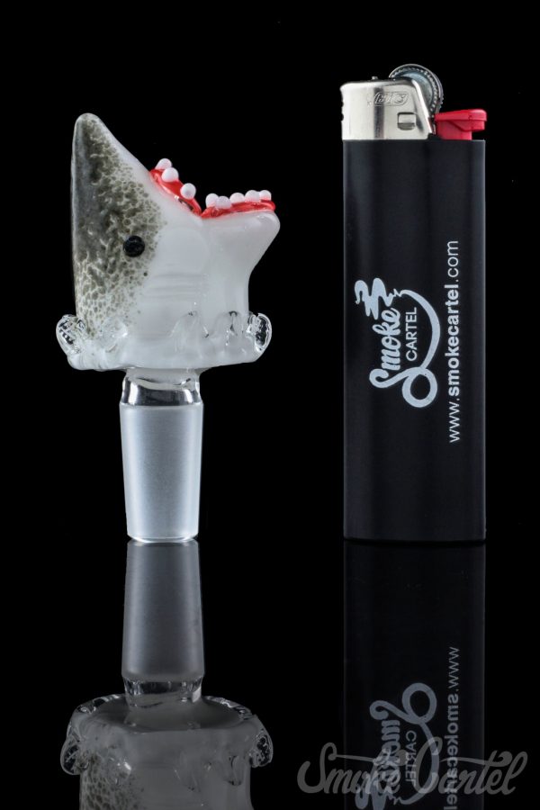 A studio shot displays the Empire Glassworks "Jawsome" Bowl Piece, with a shark-themed design reflected on a mirrored surface.