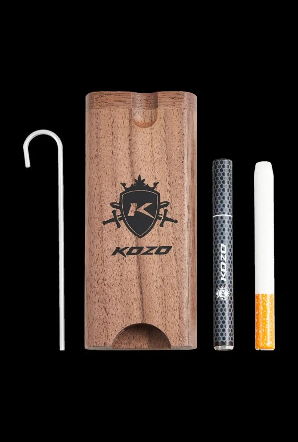 A side view of the Kozo Dugout, showcasing the wooden box with a metal pipe and a partially smoked cigarette visible inside.