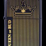 Black Zippo-style lighter with gold vertical lines and a cannabis leaf crown design, reading "Queen of Bud."