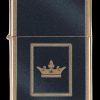 Gold Zippo-style lighter with a gold crown emblem on a black textured background.