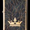 Gold Zippo lighter with a black background featuring a golden crown and cannabis leaf design.