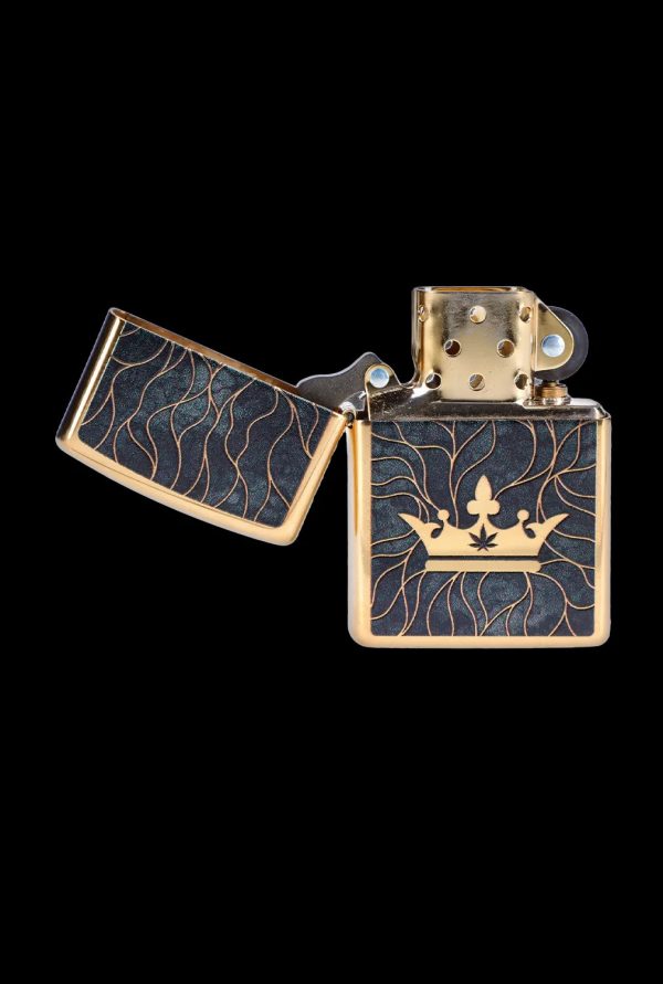 Zippo lighter with a black and gold design featuring a crown and cannabis leaf.