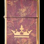 Gold lighter engraved with a crown and cannabis leaf.