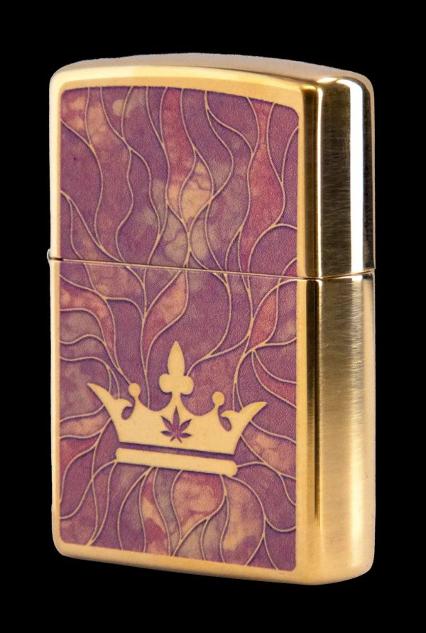 Gold Zippo lighter with a purple and gold swirling pattern and a cannabis leaf-topped crown.