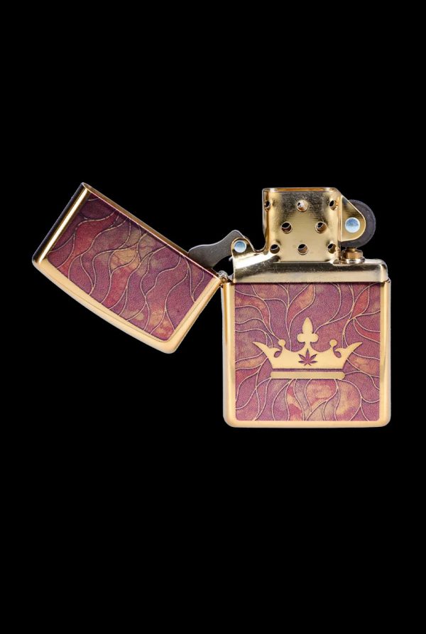 Gold lighter with a cannabis leaf-topped crown design, open to reveal the wick.