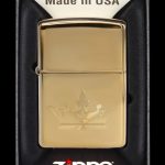 Gold Zippo lighter with engraved cannabis leaf design in its display case.