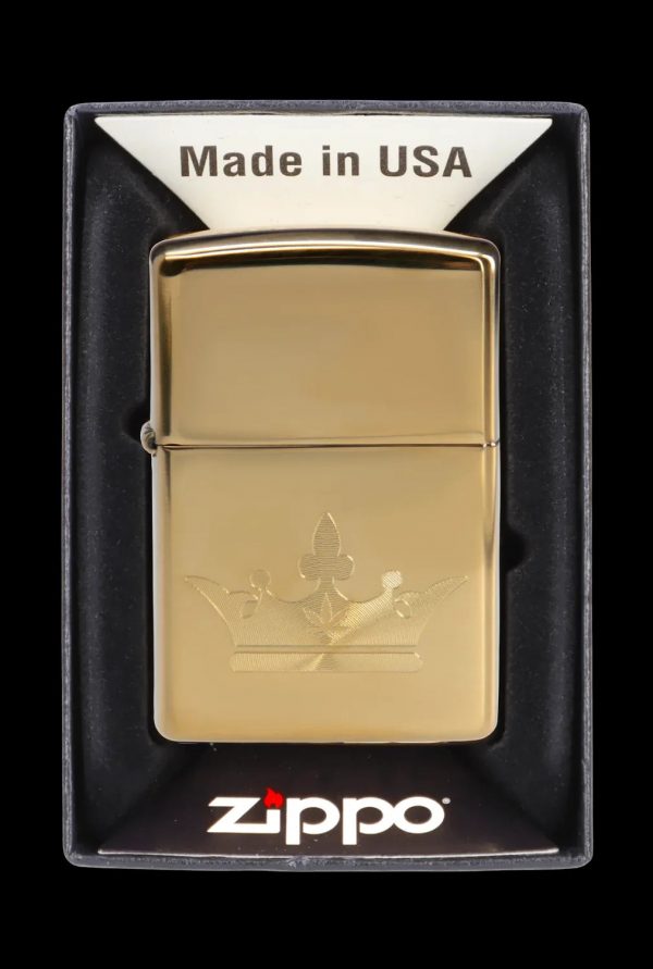 Gold Zippo lighter with engraved cannabis leaf design in its display case.