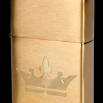 Gold Zippo lighter with a cannabis leaf design engraved on the front.