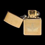 Gold Zippo-style lighter with a crown design, open and isolated on a black background.
