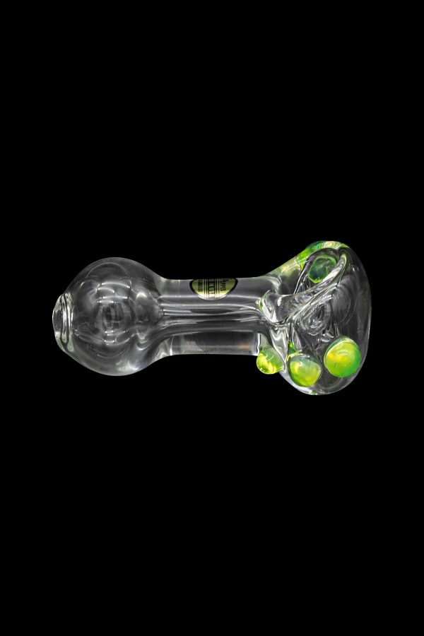 Glass pipe with green and iridescent bubbles, isolated on a black background.