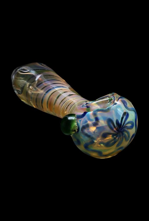 Iridescent glass pipe with floral pattern against a black background.