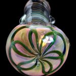 Iridescent glass cannabis water pipe with swirling green and peach floral pattern.