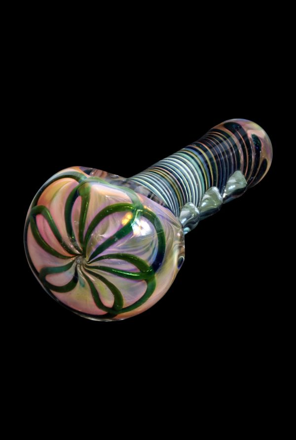 Handblown glass pipe with iridescent swirls and green leaf patterns against a black background.