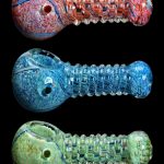 Three colorful glass pipes with intricate swirling patterns against a black background.