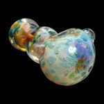 Iridescent glass cannabis water pipe with floral etching, isolated on black.