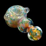 Hand-blown glass pipe with vibrant orange, blue, and green swirls against a black background.