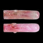 Pink glass pipe with floral swirls, displayed twice against a black background.