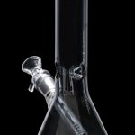Clear glass bong with intricate design, isolated on black.