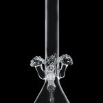 Clear glass bong with intricate percolator design against a black background.