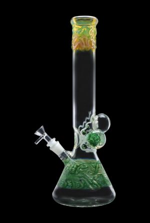 Green glass bong with intricate leaf patterns and a spherical accent, isolated on a black background.