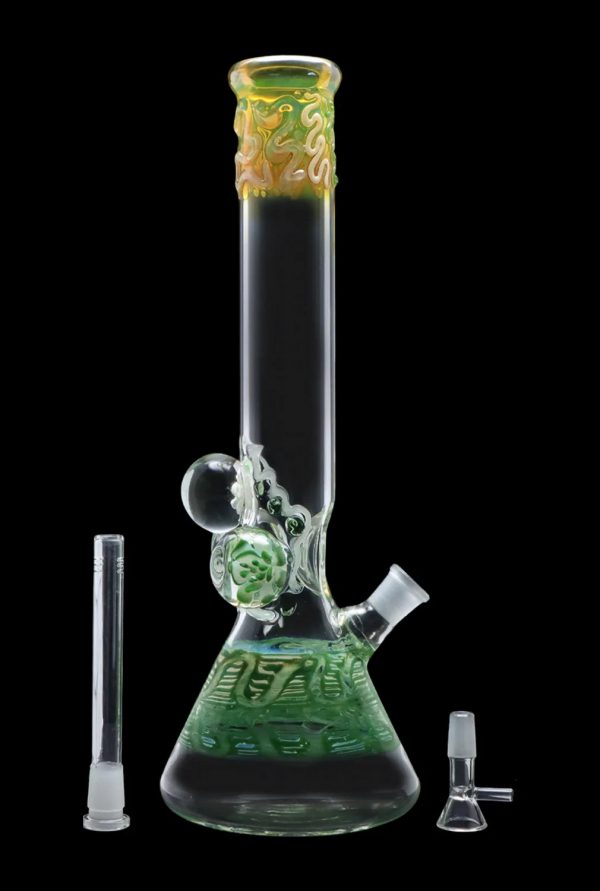 Green glass bong with intricate sculpted details, alongside a glass downstem and bowl.