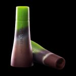 Two green silicone dab tools with “Waxology.com” printed on the side, against a black background.