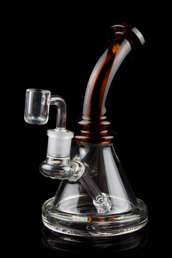 A clear glass rig with a colored mouthpiece and a quartz banger, isolated on a black background.