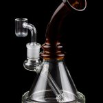 Clear glass water pipe (rig) with amber accents and a quartz banger, isolated on a black background.