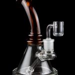 A glass bong with a flared base and amber-colored neck, featuring a quartz banger.