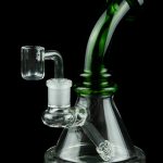 Green and clear glass dab rig with a quartz banger, isolated on a black background.