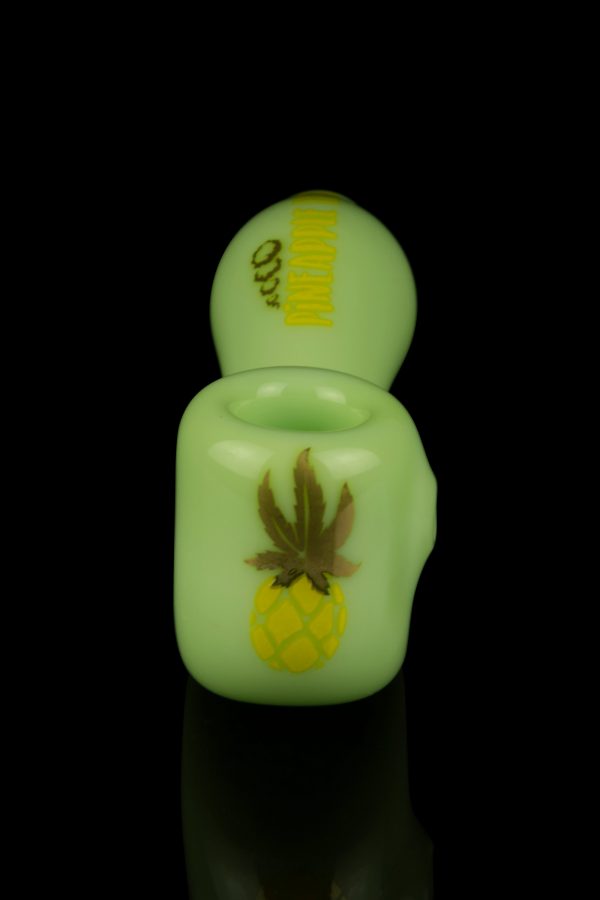 Glowing green cannabis oil vape pen with pineapple and leaf design.