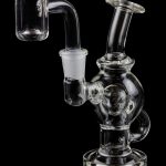 Clear glass dab rig with quartz banger, isolated on black.