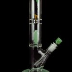 Green glass water pipe (bong) with intricate design, studio shot.