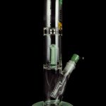 Green glass water pipe with multiple diffusion tubes, isolated on a black background.