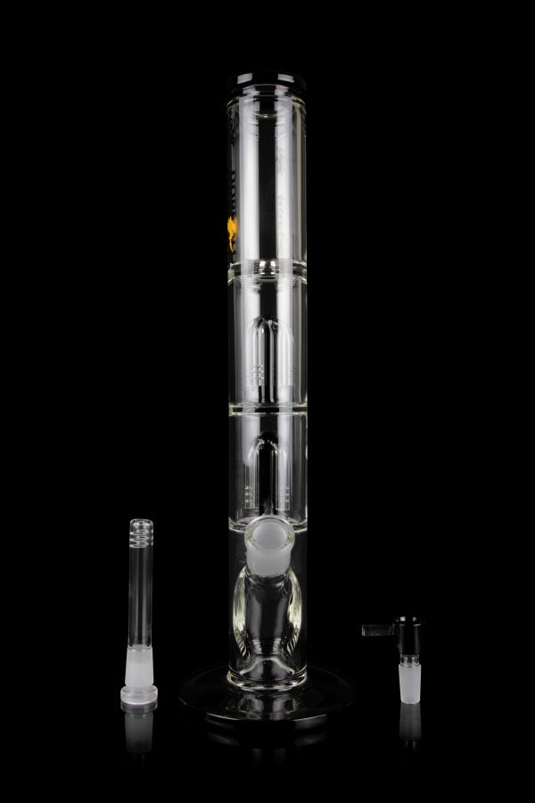 Clear glass bong with multiple filtration chambers and accompanying glass pieces, displayed on a reflective surface against a black background.