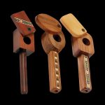 A detailed side view of the Marquee Inlaid Wood Spoon Pipe with Swivel Lid, showcasing its wooden construction and patterned inlay.