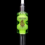 Green and silver cannabis oil syringe with “Freak Street” branding against a black background.