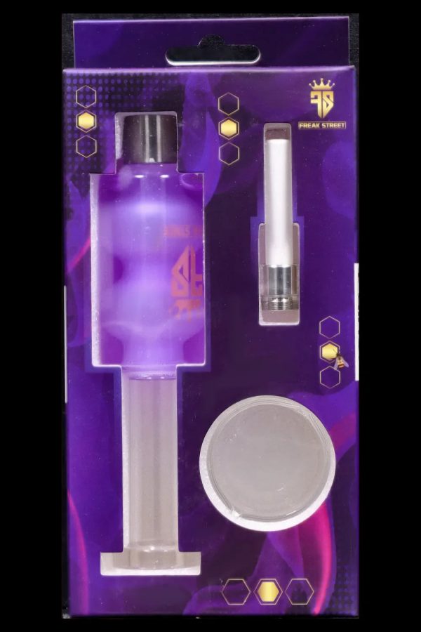 Clear glass cannabis oil rig and accessories packaged on a purple and blue display card with the "Freak Street" logo.