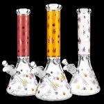 Three patterned glass bongs with cannabis leaf designs against a black background.