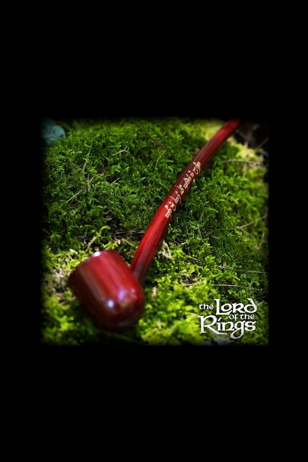 Red glass pipe resting on a bed of vibrant green moss, evoking a natural, earthy aesthetic.