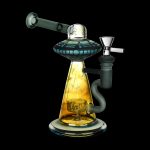 A colorful glass dab rig with a UFO-shaped perc, set against a black background.