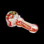 Red and orange glass pipe with intricate latticework detail, isolated on a black background.