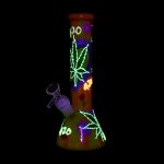 A glowing glass water pipe decorated with cannabis leaves and “420” text, alongside a metal dab tool.