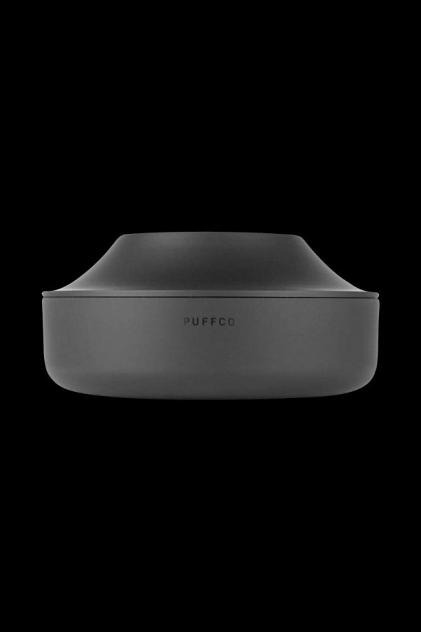 A studio shot of the Puffco Peak Pro Power Dock, showcasing its sleek, black, circular design from a slightly angled, top-down perspective.