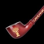 Red glass pipe with gold floral and geometric designs, isolated on a black background.