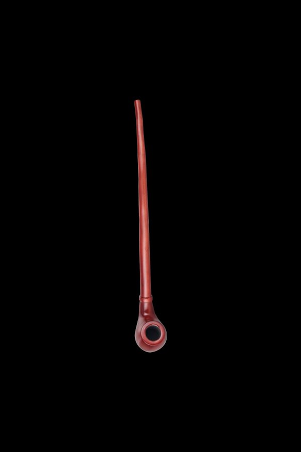 Red glass chillum pipe against a black background.