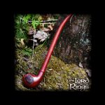 A long, curved, reddish-brown smoking pipe rests on a mossy surface, evoking imagery from *The Lord of the Rings*.