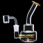 Clear glass dab rig with a quartz banger and colorful branding.