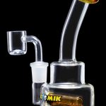 Clear glass dab rig with a quartz banger and colorful accents.